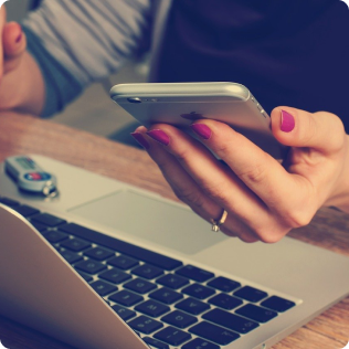 A person is using their phone while sitting at the table.