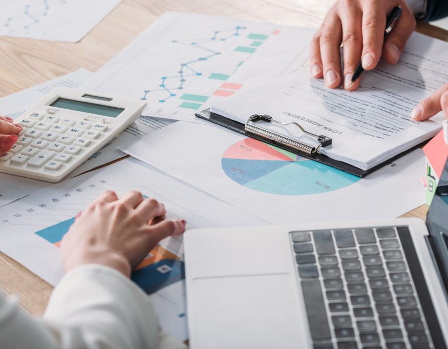 partial-view-of-man-studying-loan-agreement-and-businesswoman-using-calculator-while-sitting-at.jpg partial-view-of-man-studying-loan-agreement-and-businesswoman-using-calculator-while-sitting-at.jpg
